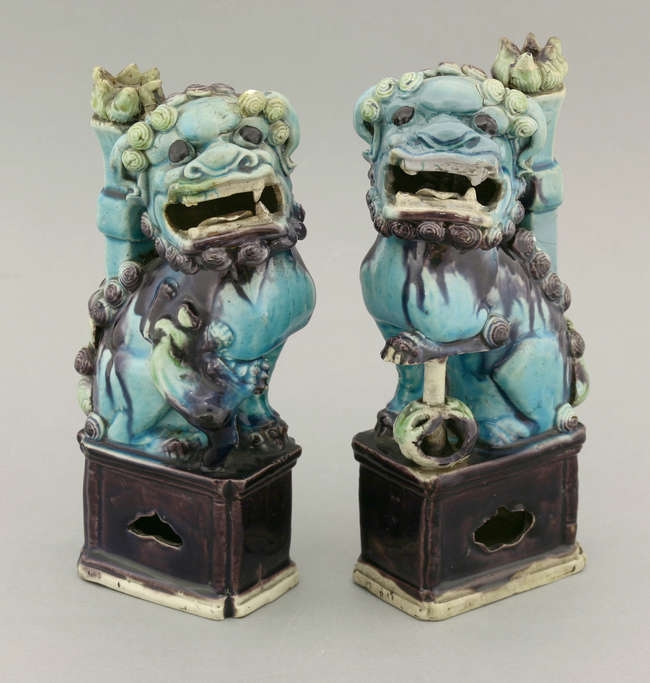 Apair of enamelled biscuit Buddhist Lion Incense-Stick Holders