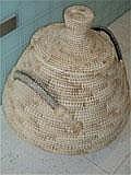 A large wicker laundry basket and cover
