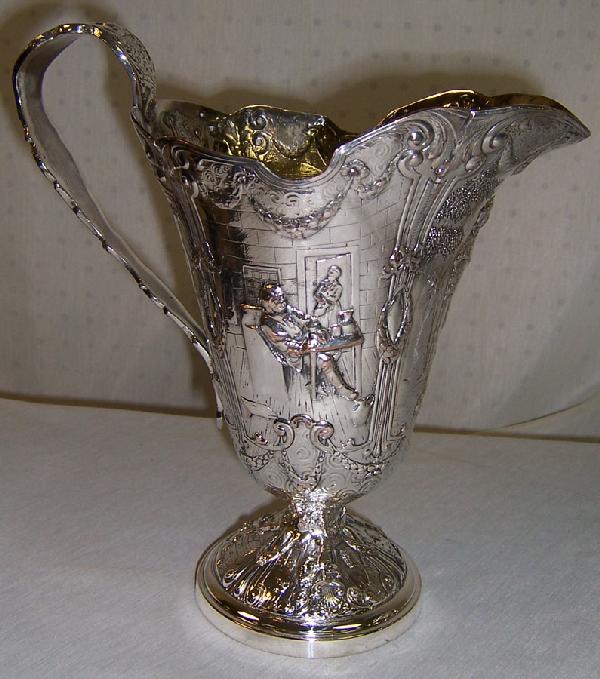 Dutch scene hand chased silver on copper pitcher.