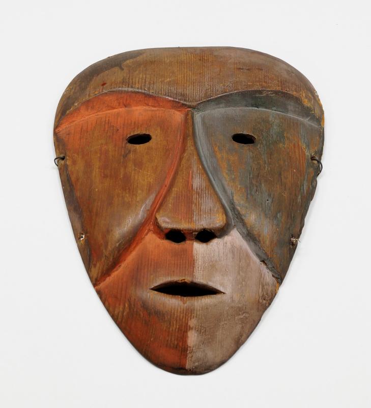 An Inuit carved wood mask, 19th century, with domed forehead, diminutive