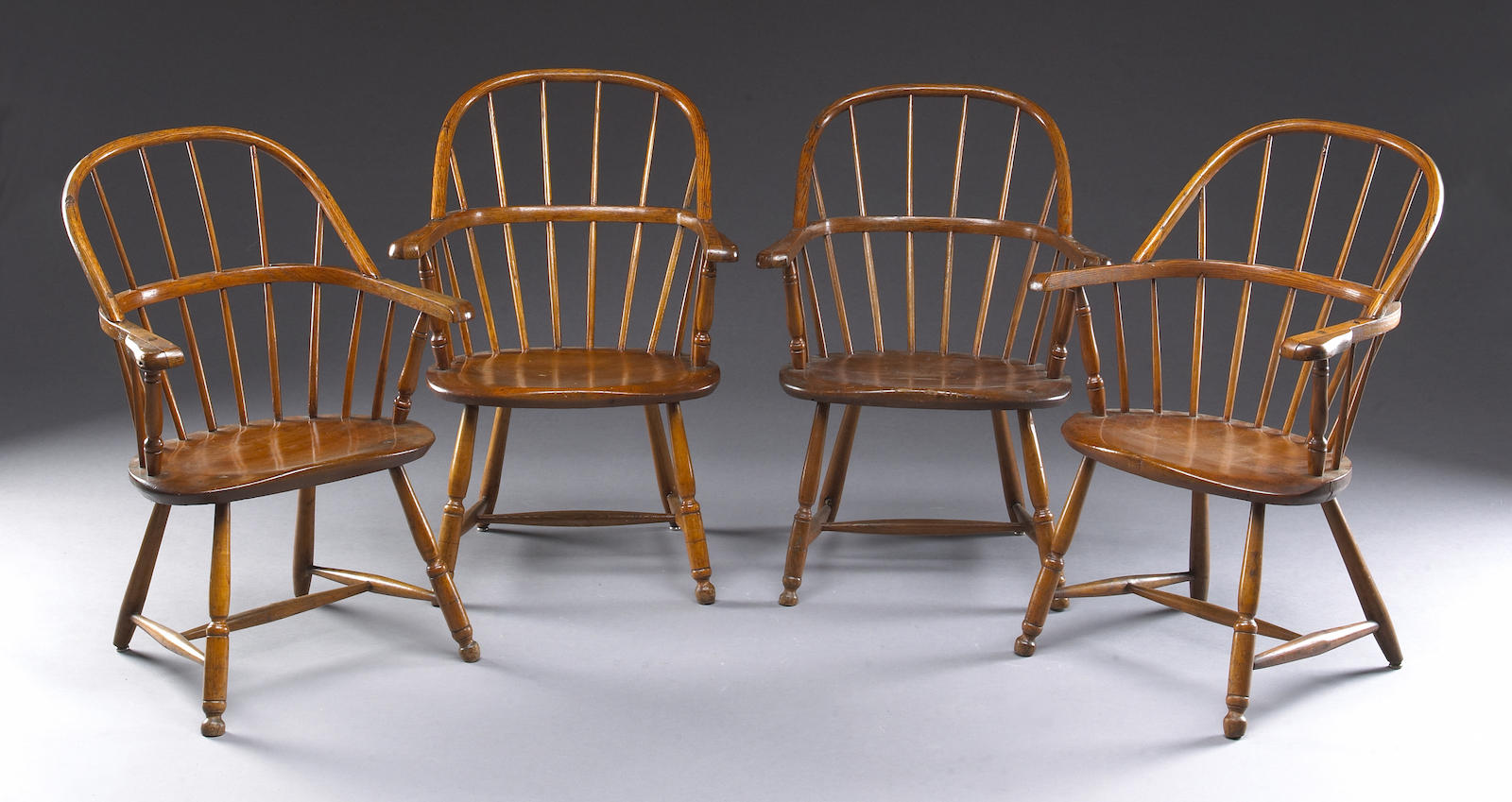 A set of four mixed wood sack back Windsor armchairs