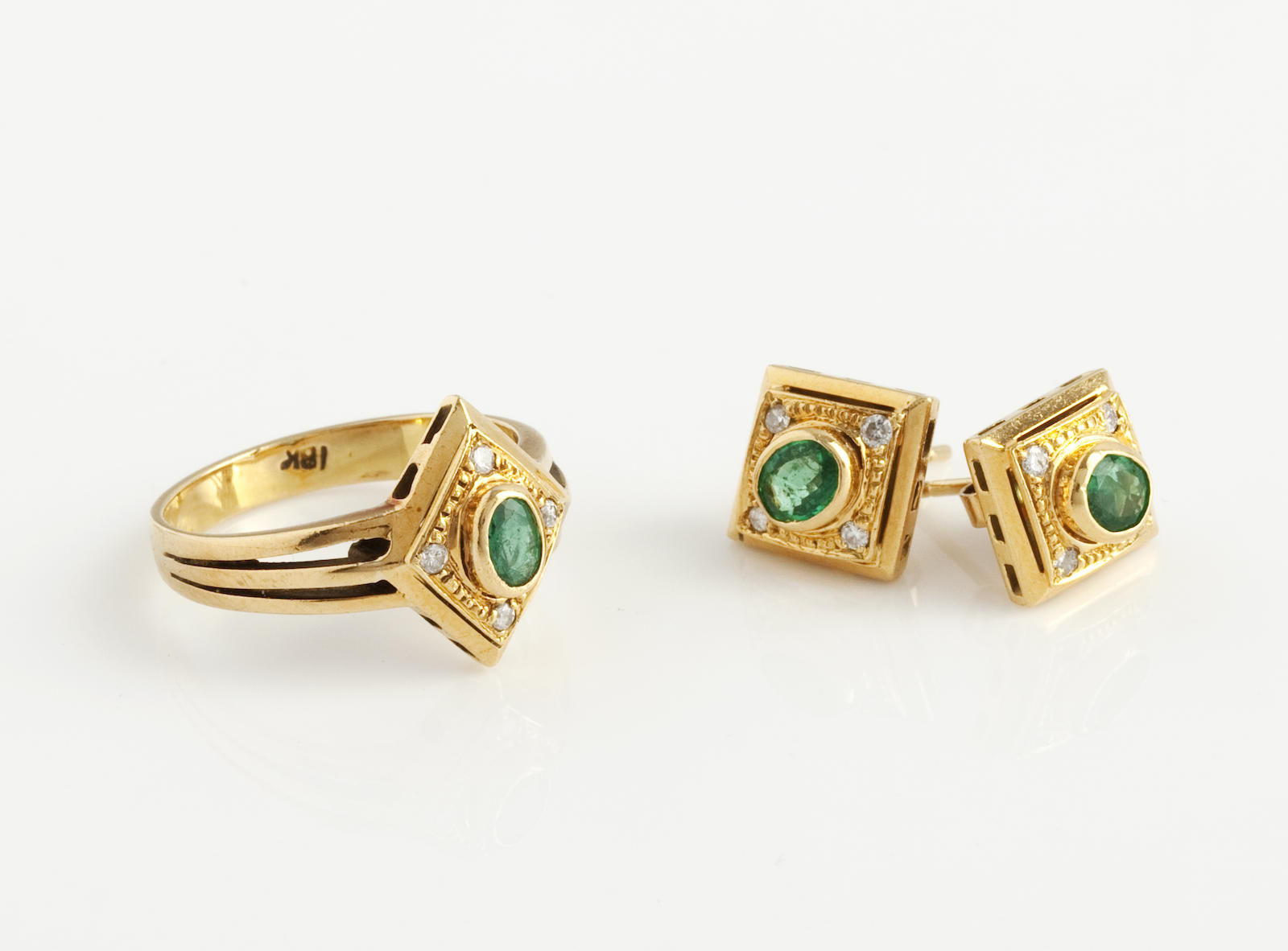 An emerald and diamond ring and earring suite