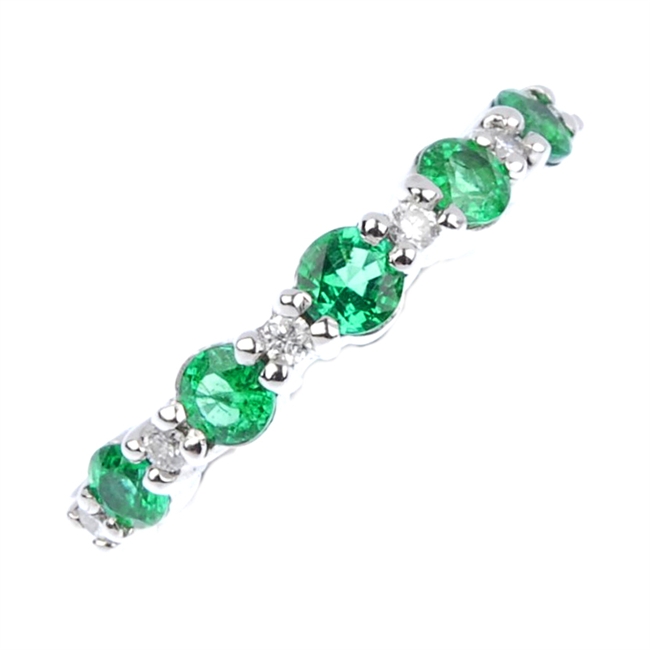 An emerald and diamond half eternity ring.