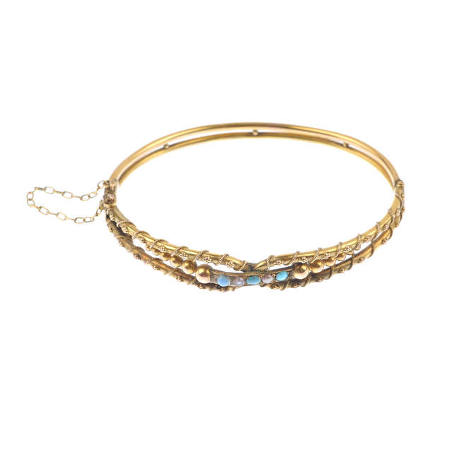 An early 20th century 9ct gold turquoise and split pearl hinged bangle.