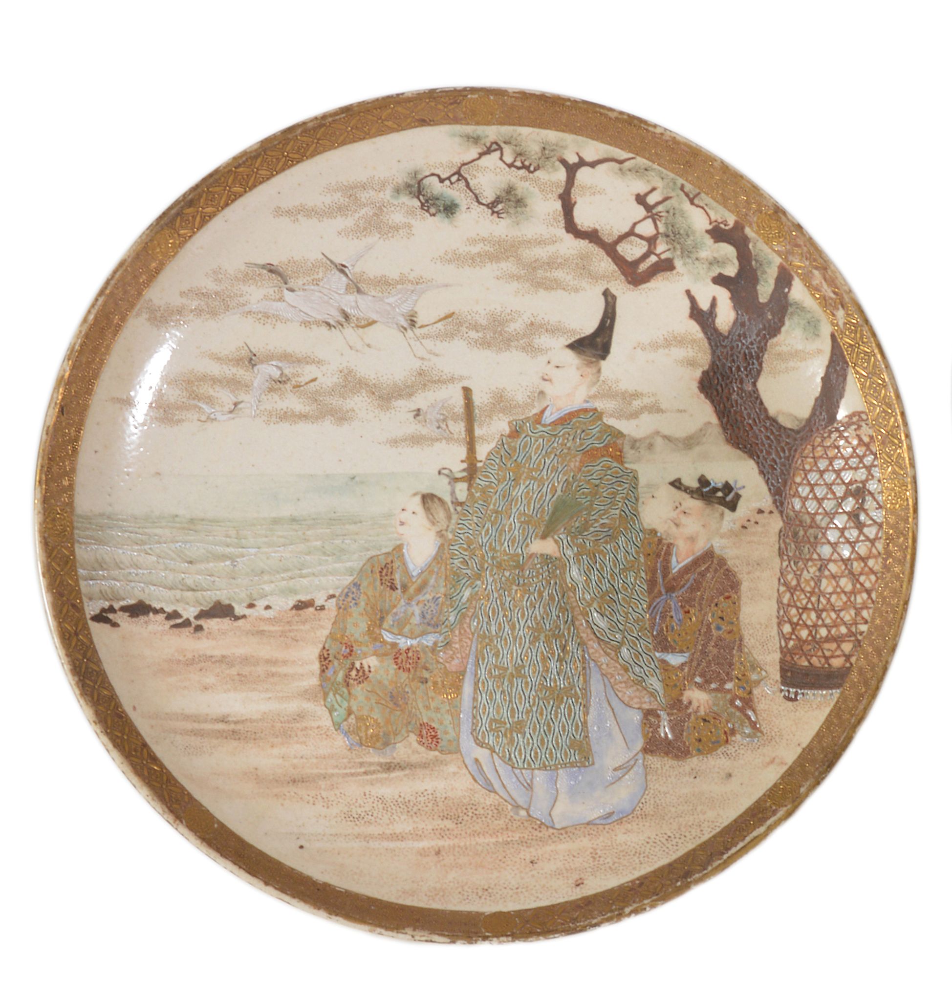 A Japanese Satsuma pottery dish of shallow circular form with upturned rim