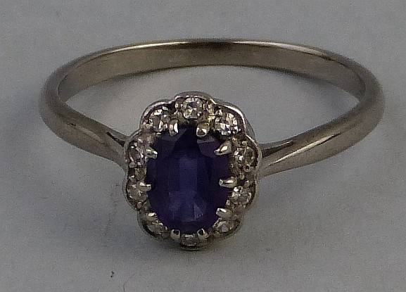 An amethyst and diamond cluster ring, comprising a central oval amethyst su