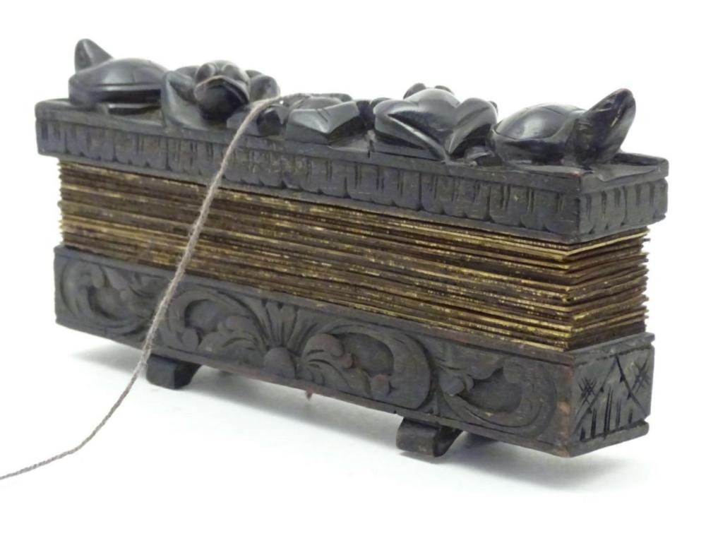A 19thC prayer book with carved wooden covers with frog, turtle, floral and foliate detail, containi