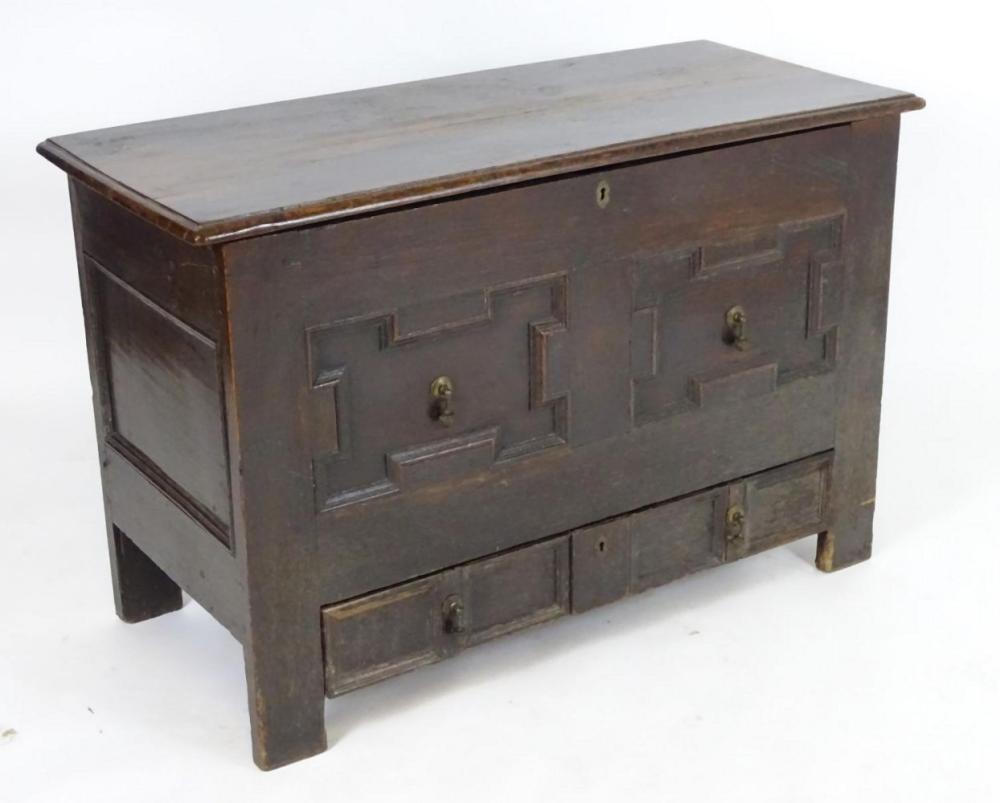A late 17thC oak mule chest with a moulded lifting lid above a panelled front having geometric mould
