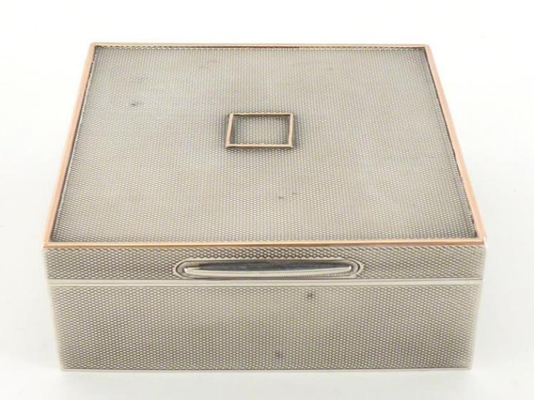 A silver engine-turned square cigarette box with gold...
