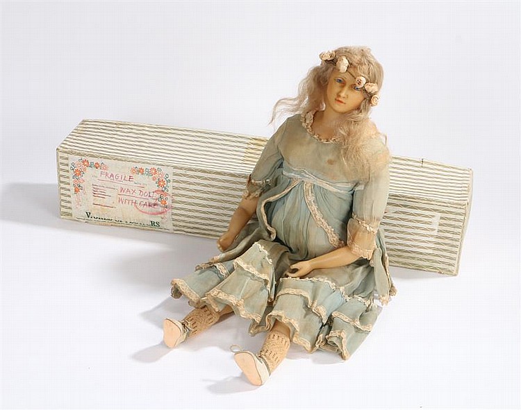 Wax doll with blonde hair and blue eyes