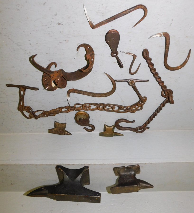 Assorted iron anvils and chains and wooden anvil.