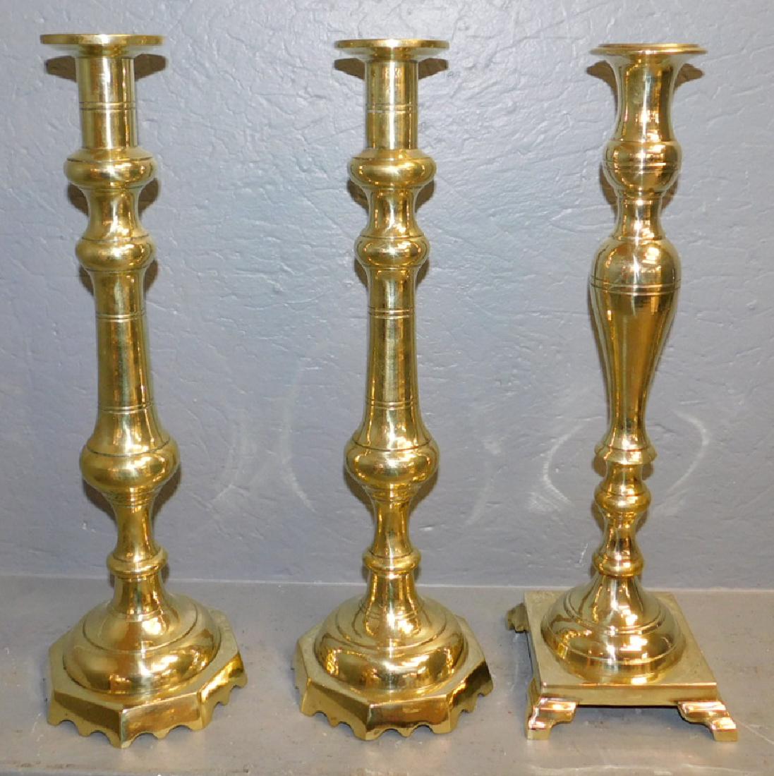 Pair and single large polished brass candlesticks