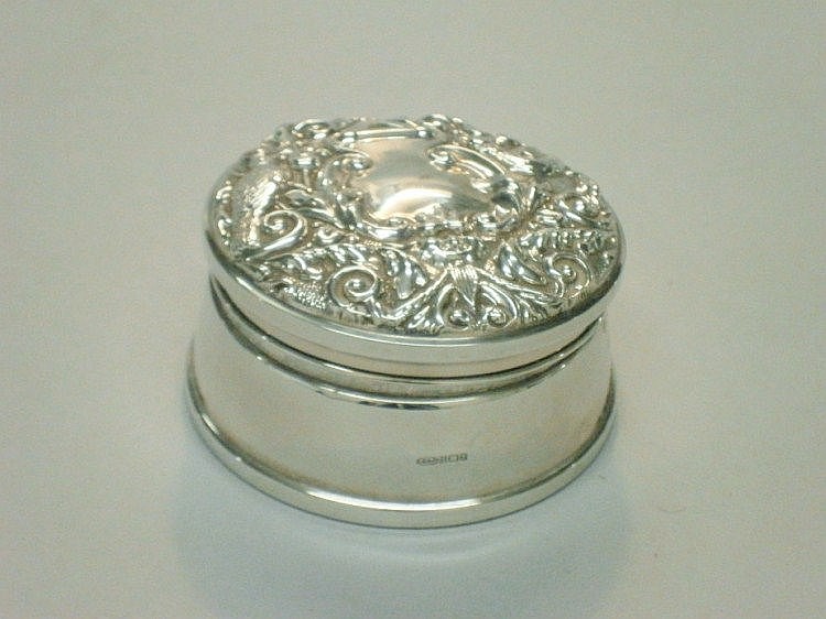 A circular silver trinket box, the hinged lid