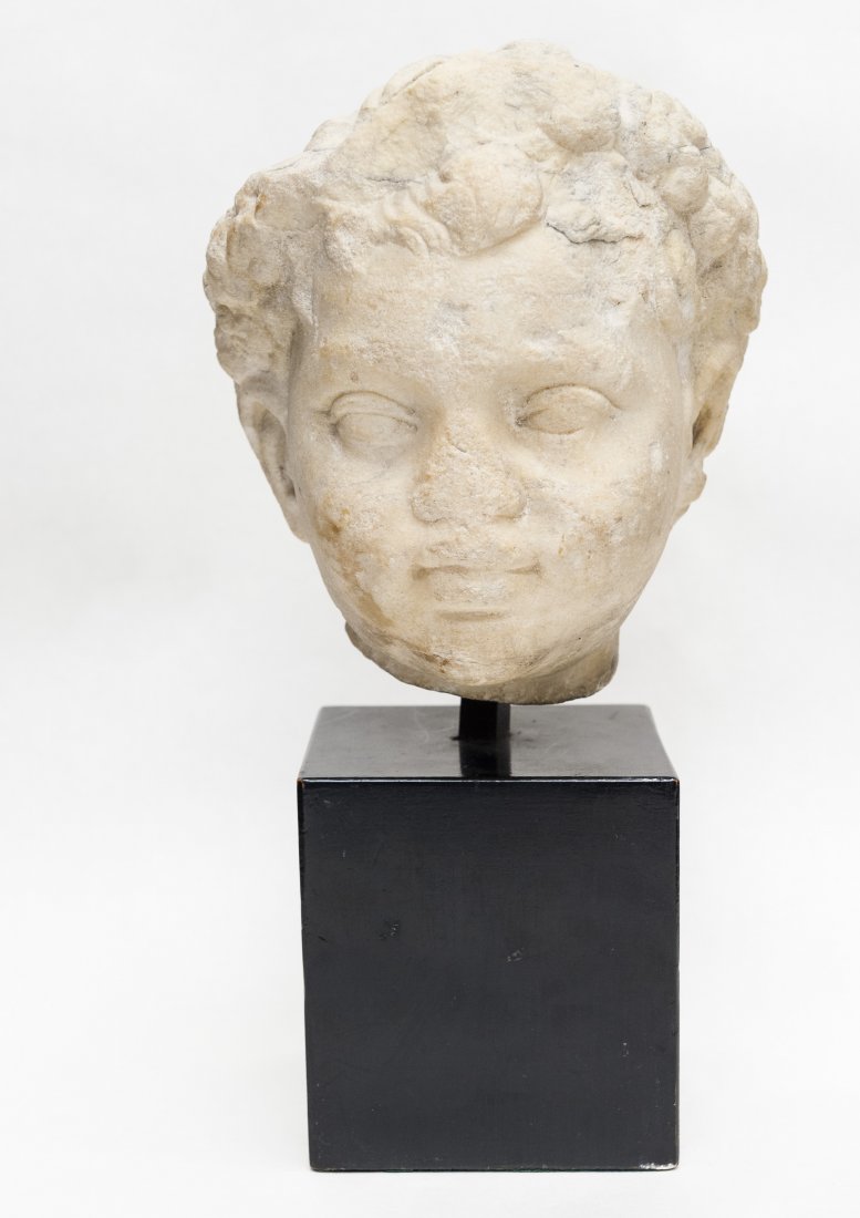 Ancient carved limestone head of a boy.