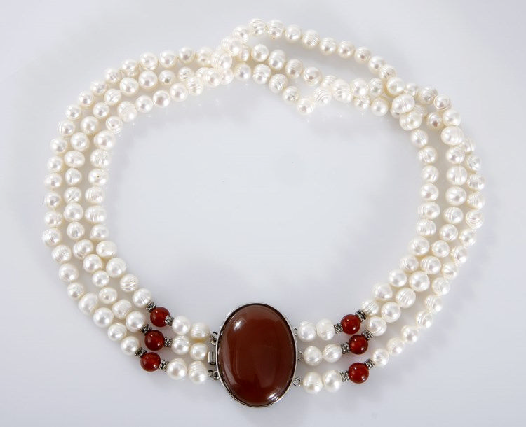 A THREE-STRAND PEARL CHOKER composed of three strands of cultured pearls