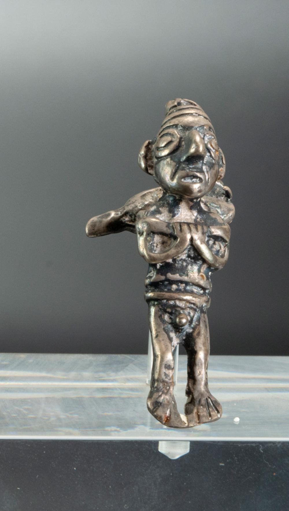 A Silver Miniature Figurine Showing a Walking Man carrying a Bundle