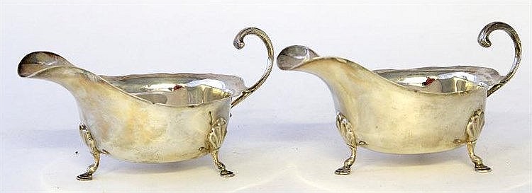 A silver pair of sauce boats Of conventional form