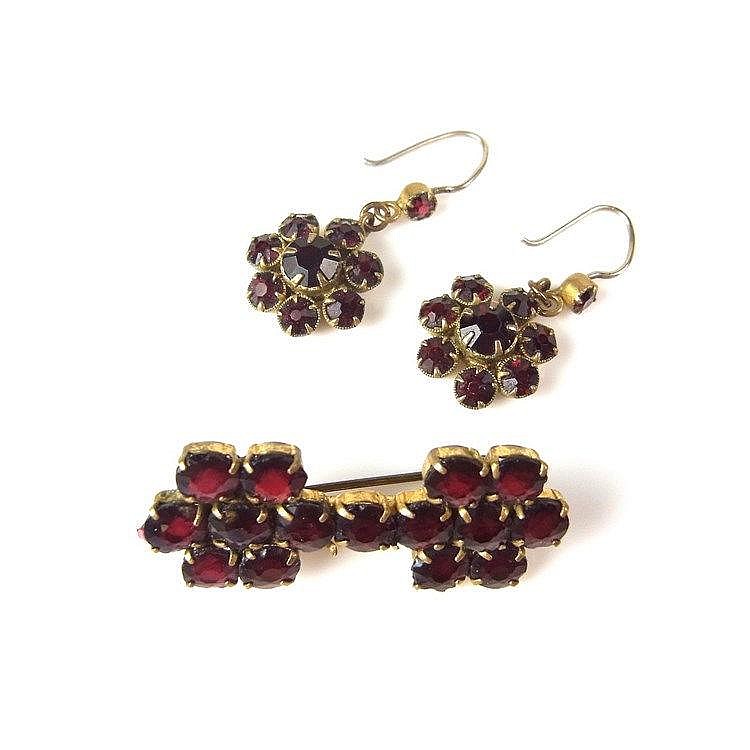 Yellow metal garnet brooch and earrings. Both set with circular cut garnets