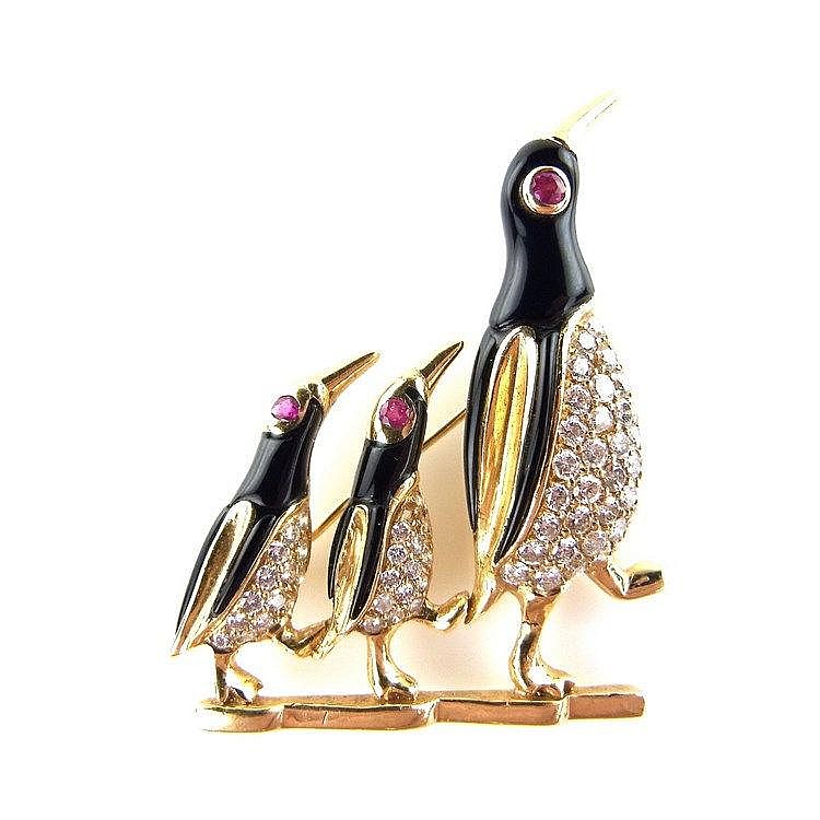 18 ct yellow gold penguin brooch. Designed as three marching penguins, two