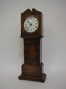 AN OAK TIMEPIECE, formed as a miniature longcase clock, height 38cm