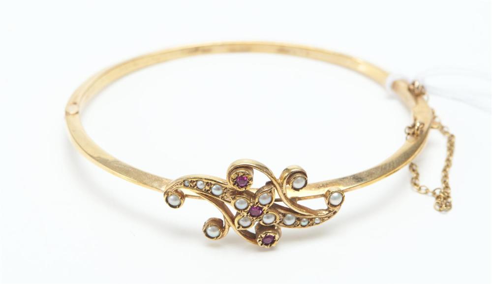 AN ANTIQUE RUBY AND SEED PEARL HINGED BANGLE IN 9CT GOLD