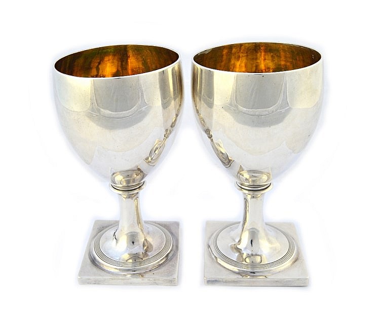 A pair of George III silver goblets, each decorated with a circular reeded