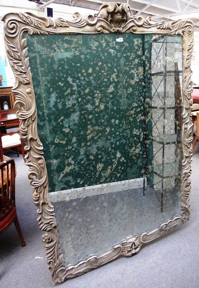 A large 19th century wall mirror, the carved and painted shaped frame with