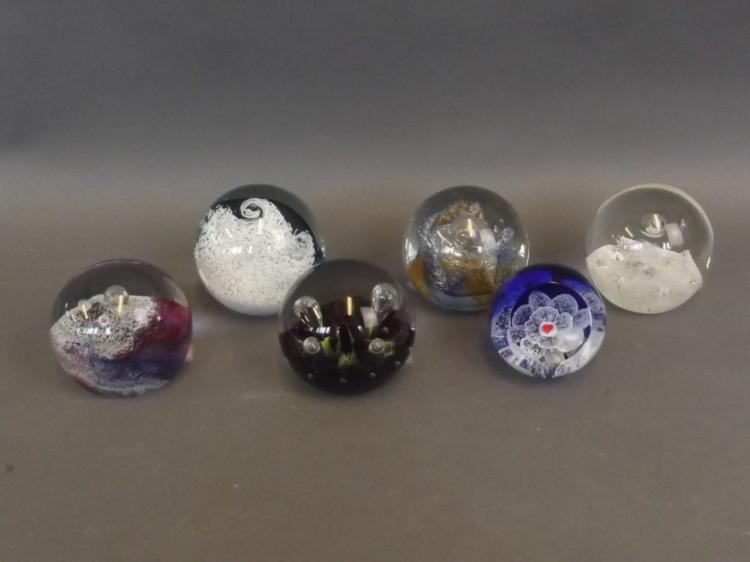 A collection of six Caithness Art glass paperweights...
