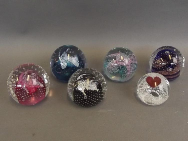 A collection of six Caithness Art glass paperweights...