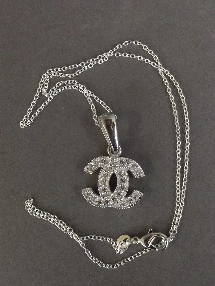 A Chanel style interlocking 'C' silver and cubic zirconia...
