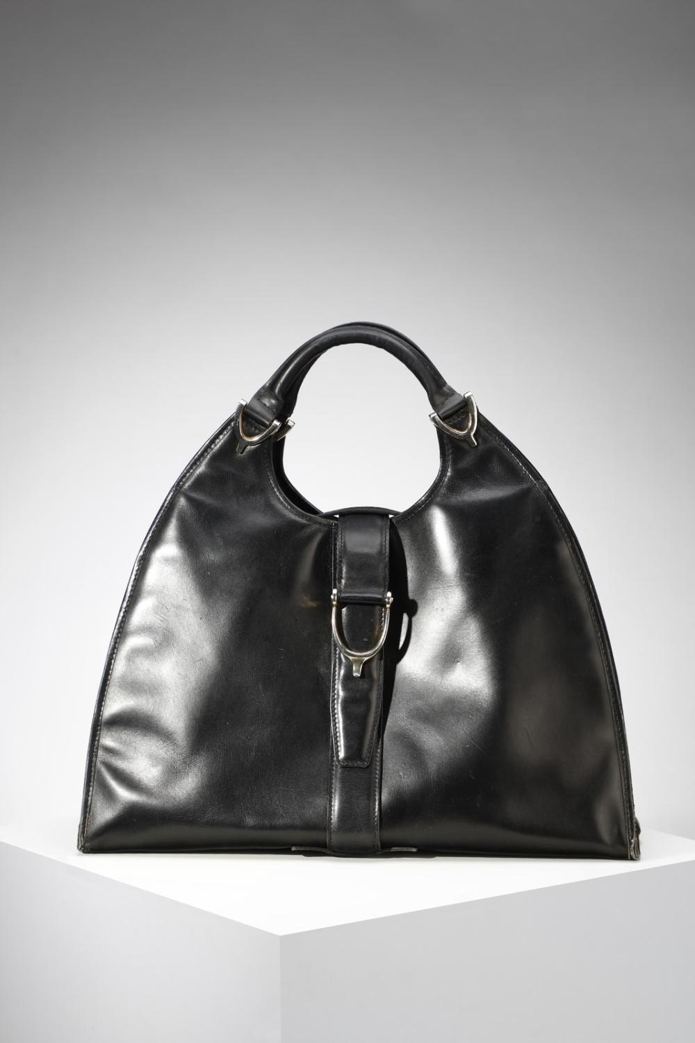 GUCCI Black leather handbag. Buckle closure.