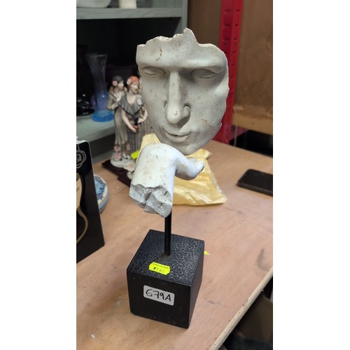 Modern composite sculpture of a stylised human mask and outs...